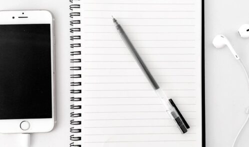composition of notebook with pen near smartphone